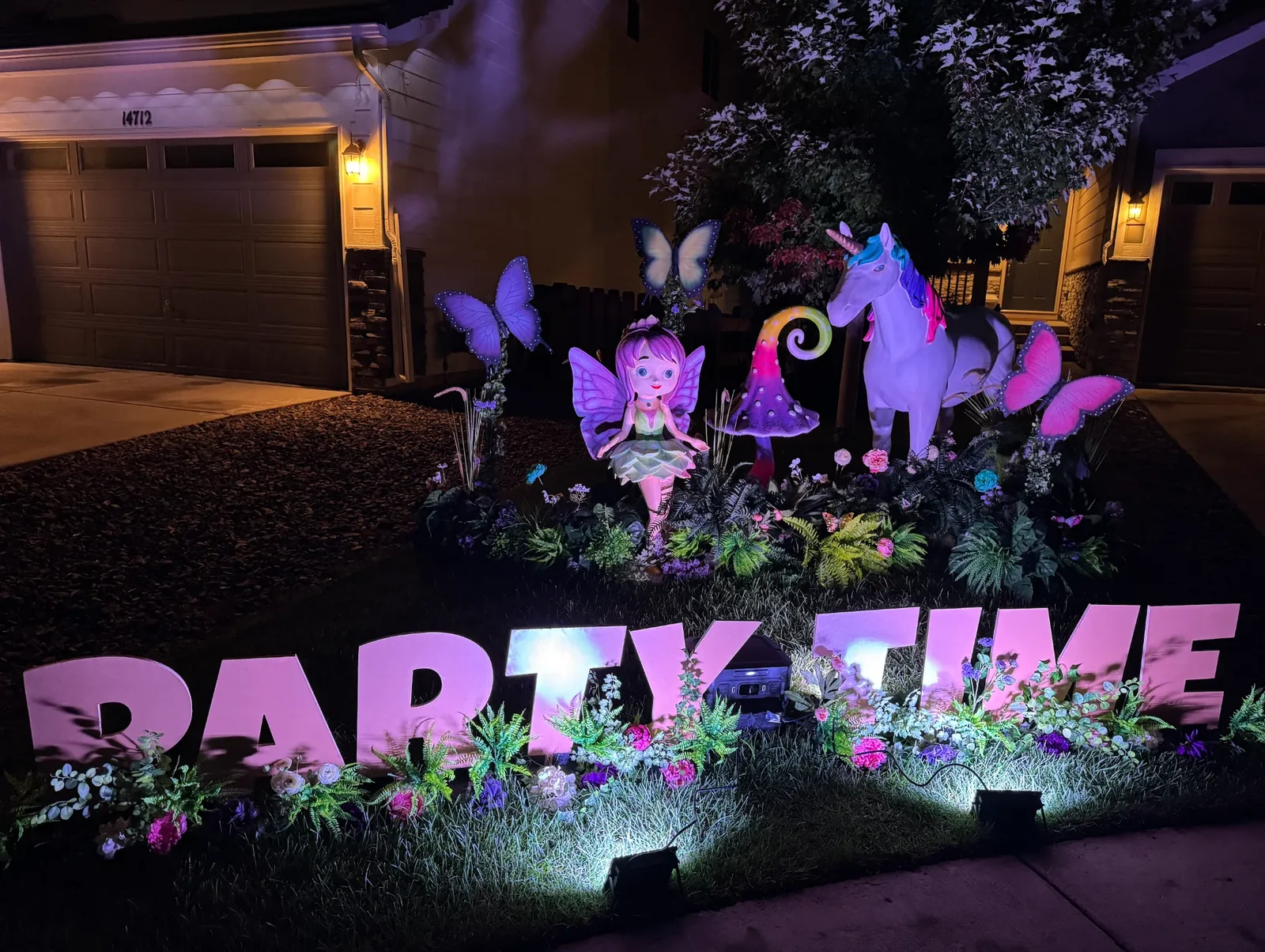 Enchanted Garden Legend package after dark — full yard display with illuminated letters